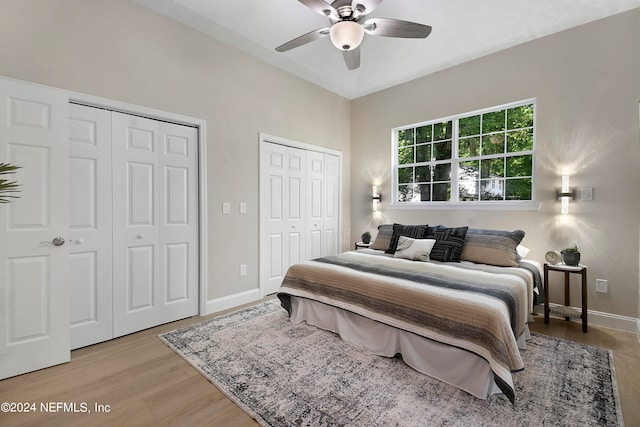 bedroom featuring multiple closets, ceiling fan, and light hardwood / wood-style floors