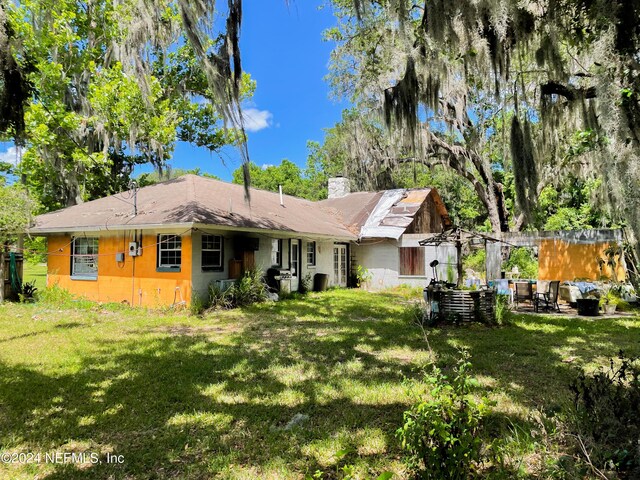 back of house with a lawn