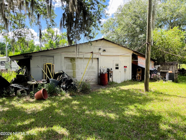 exterior space with a garage and a lawn