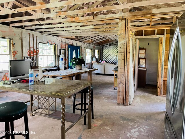 interior space with concrete floors and stainless steel refrigerator