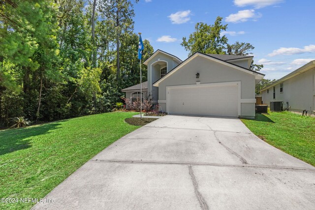 view of front facade with a garage, central AC, and a front yard