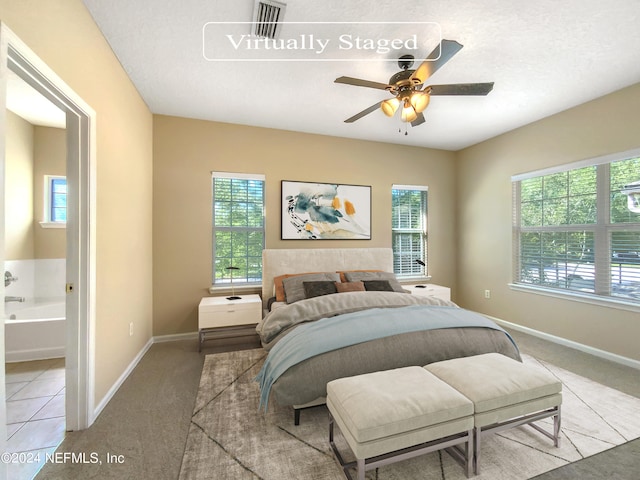 carpeted bedroom featuring multiple windows, ceiling fan, and a textured ceiling