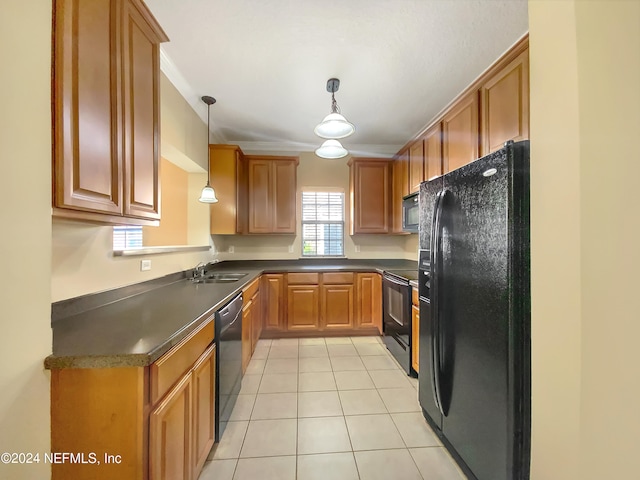 kitchen with sink, light tile patterned flooring, black appliances, and decorative light fixtures