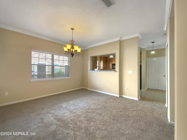 carpeted spare room featuring a textured ceiling, crown molding, and an inviting chandelier