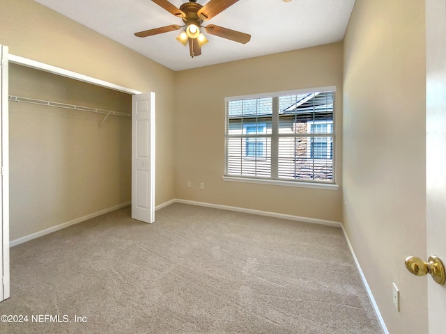 unfurnished bedroom with a closet, light colored carpet, and ceiling fan