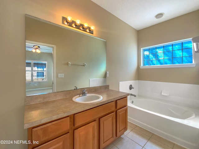 bathroom with tile patterned floors, ceiling fan, a bathtub, and vanity