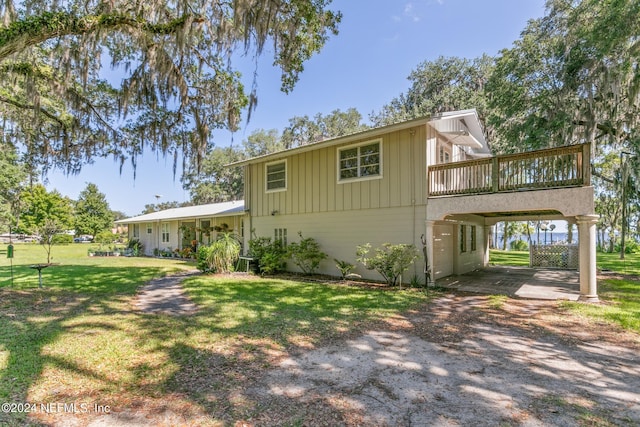 view of front of property featuring a wooden deck, a front lawn, and a carport