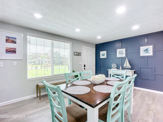 dining room featuring light hardwood / wood-style floors and a textured ceiling