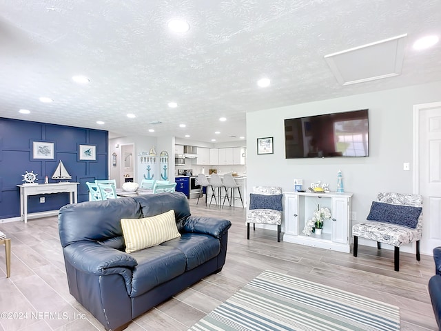 living room with a textured ceiling and light hardwood / wood-style floors