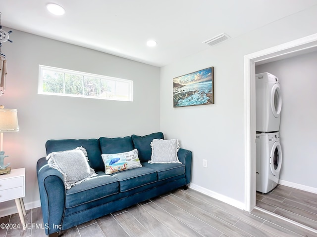 living room with stacked washer and dryer and light hardwood / wood-style flooring