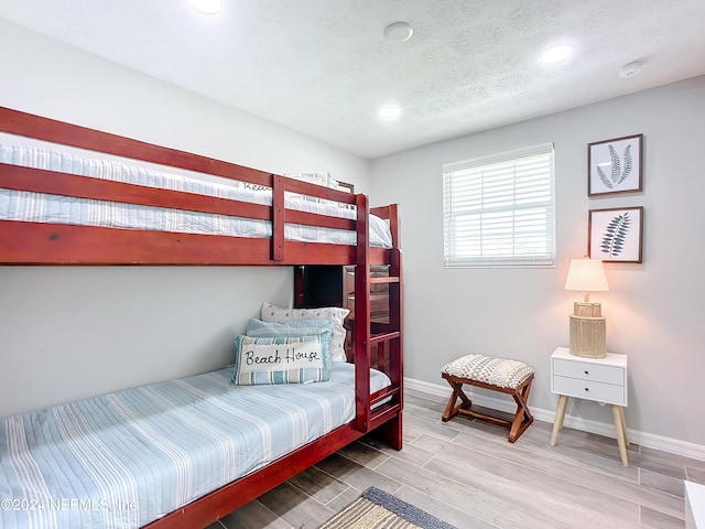 bedroom with hardwood / wood-style floors and a textured ceiling