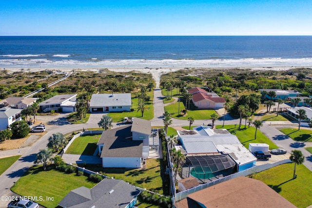 birds eye view of property with a water view and a beach view