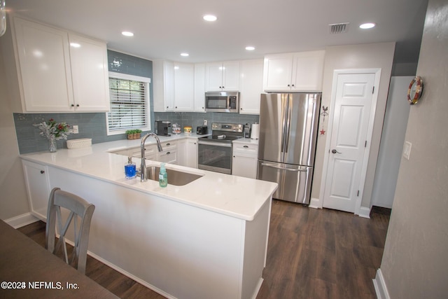 kitchen featuring stainless steel appliances, a peninsula, visible vents, white cabinets, and light countertops