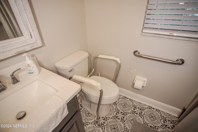 bathroom featuring vanity, tile patterned flooring, toilet, and baseboards