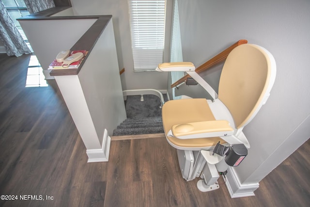 staircase featuring wood finished floors, a wealth of natural light, and baseboards