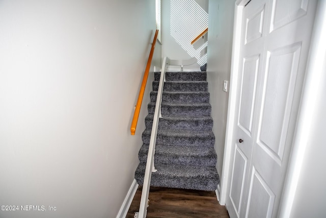 stairway with wood finished floors and baseboards