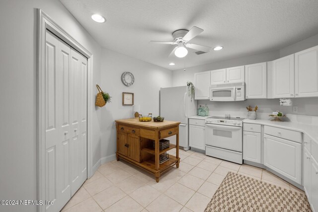 kitchen featuring white appliances, white cabinets, ceiling fan, and light tile floors