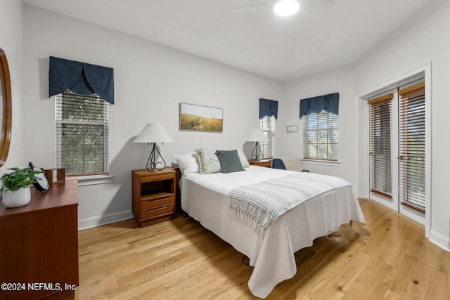 bedroom with ceiling fan, access to exterior, and hardwood / wood-style floors