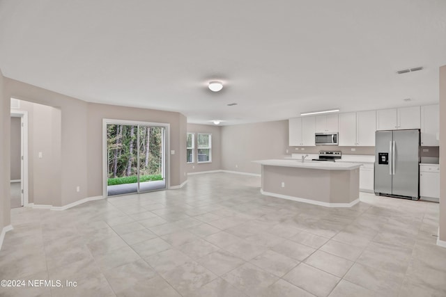 kitchen with a kitchen island with sink, sink, light tile patterned floors, white cabinetry, and stainless steel appliances