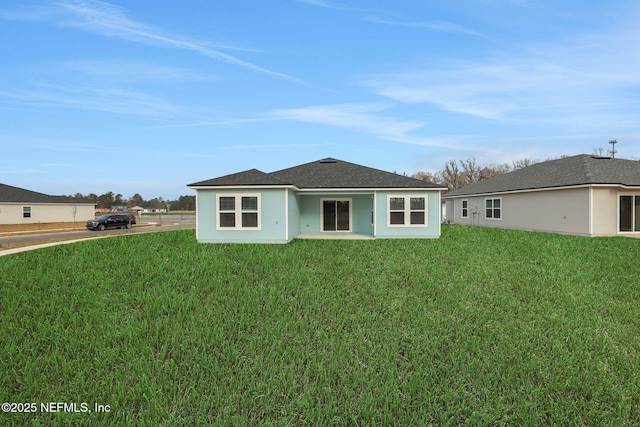 rear view of property with a yard and stucco siding