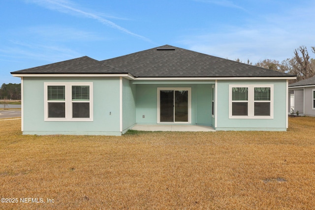 back of house featuring roof with shingles and a yard