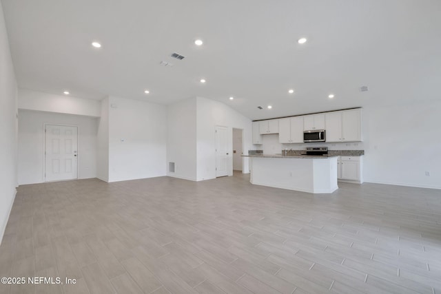 unfurnished living room with light wood-type flooring, visible vents, and recessed lighting