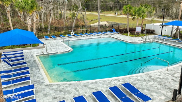 community pool featuring fence and a patio