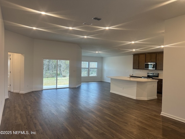 unfurnished living room with dark wood finished floors, baseboards, and a sink