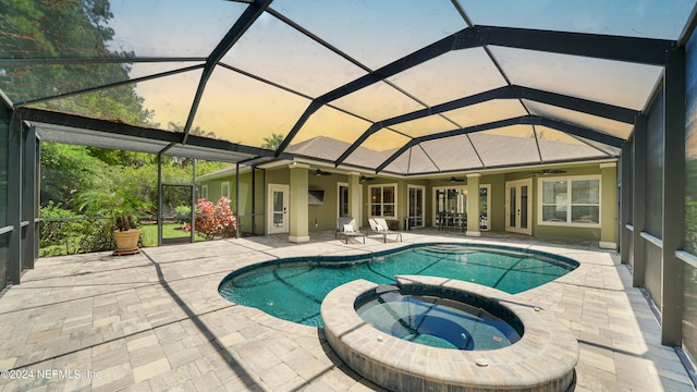 view of swimming pool featuring glass enclosure, an in ground hot tub, and a patio