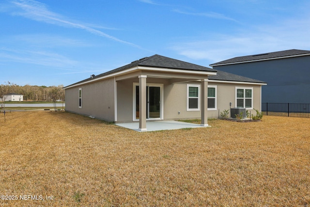 back of property with fence, stucco siding, a lawn, cooling unit, and a patio