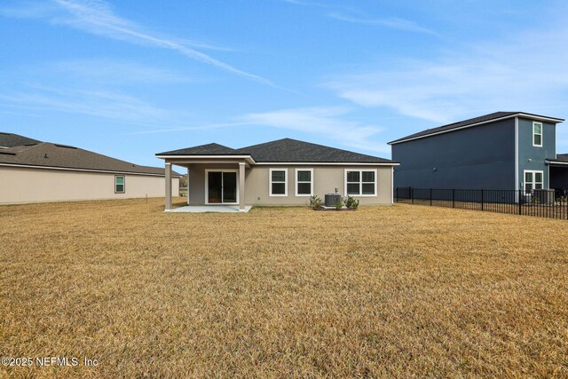 rear view of property featuring a yard, central air condition unit, a patio area, and fence