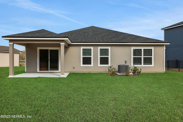 back of property with central AC, fence, a yard, and roof with shingles