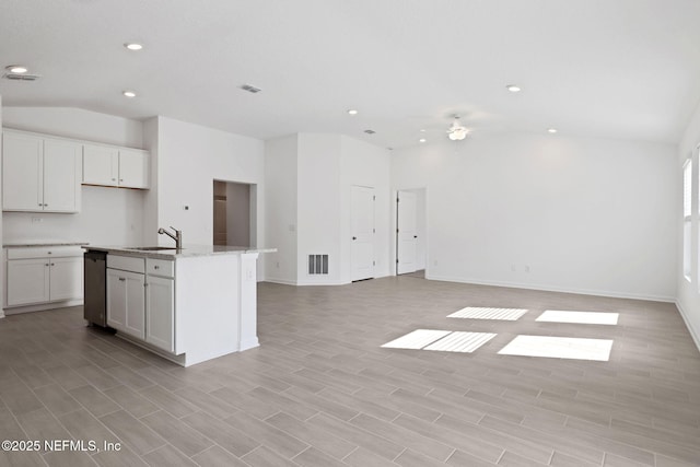 kitchen featuring vaulted ceiling, open floor plan, visible vents, and a sink