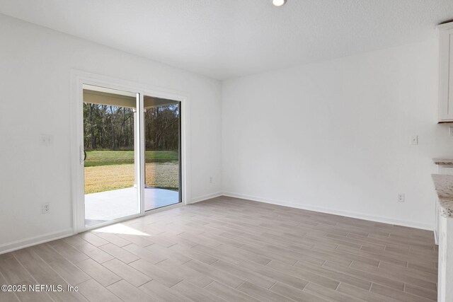 empty room with baseboards and wood finish floors