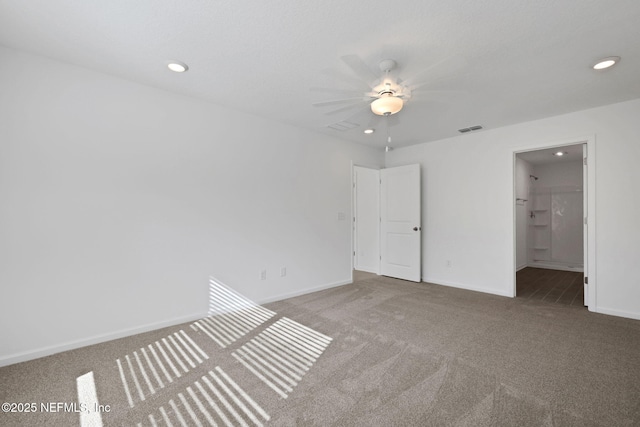 carpeted spare room featuring recessed lighting, baseboards, and visible vents