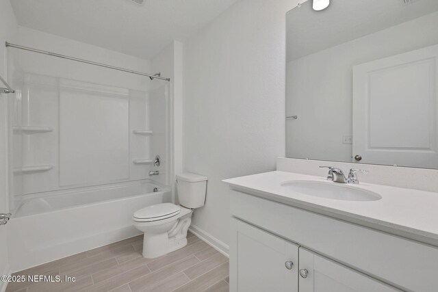 full bath with baseboards, wood tiled floor, toilet, shower / bath combination, and vanity