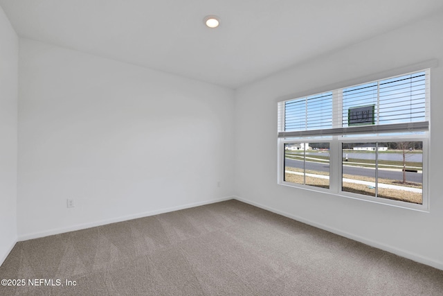 unfurnished room with baseboards and carpet floors