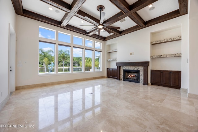 unfurnished living room with ceiling fan, a high end fireplace, and built in features