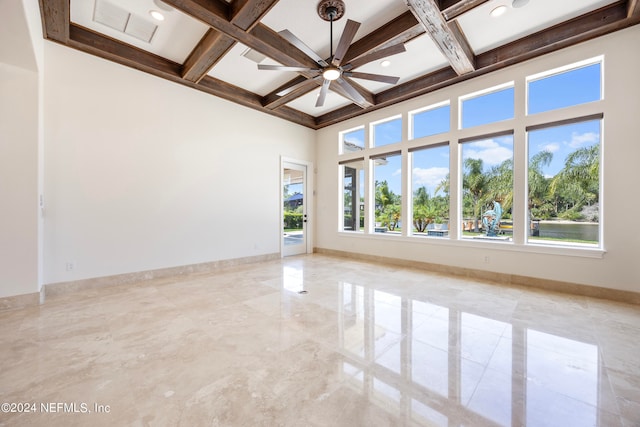 unfurnished room with ceiling fan, a wealth of natural light, and coffered ceiling