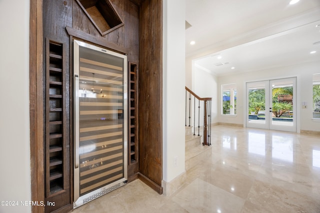 entryway with ornamental molding, wine cooler, and french doors