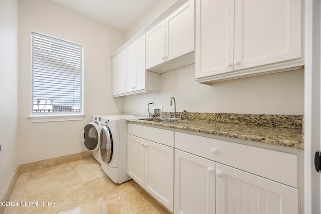 laundry area with cabinets, sink, washing machine and dryer, and light tile patterned flooring