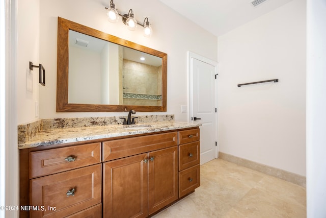 bathroom with tile patterned flooring, walk in shower, and vanity