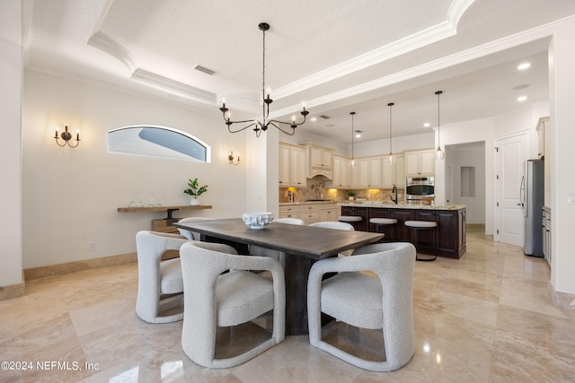 dining room with crown molding, sink, a tray ceiling, and a chandelier