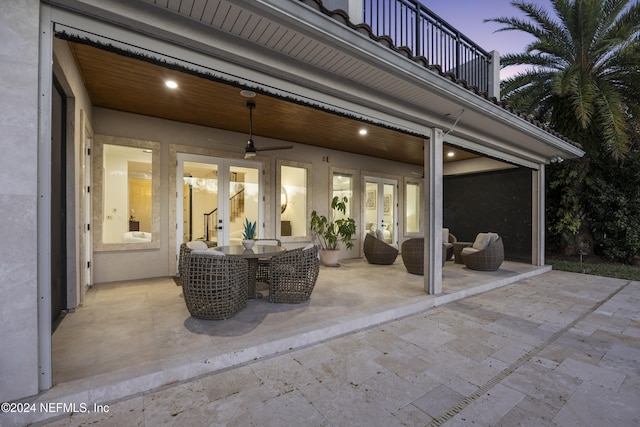 patio terrace at dusk with ceiling fan and a balcony