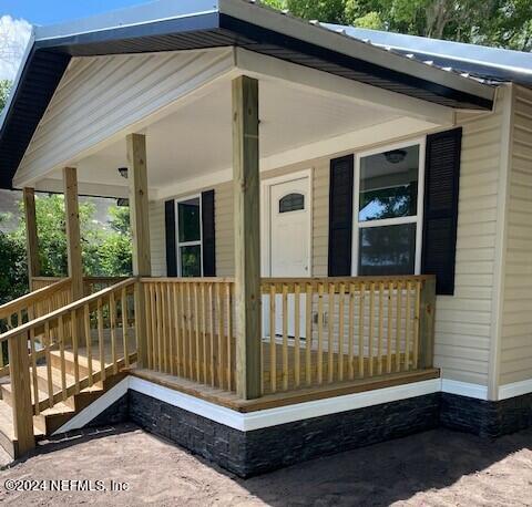 doorway to property featuring covered porch