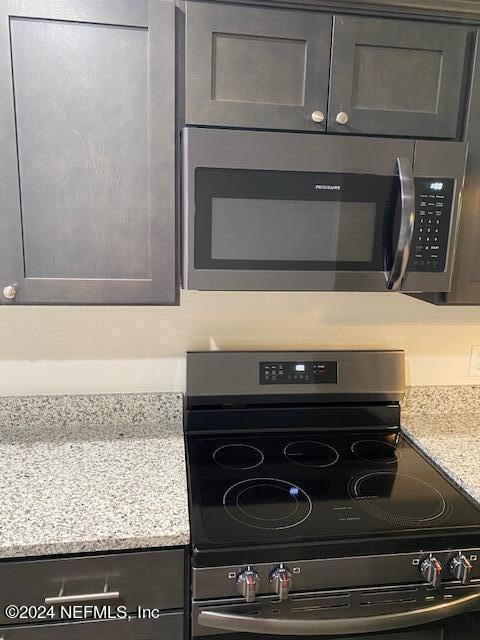 interior details featuring light stone counters and appliances with stainless steel finishes