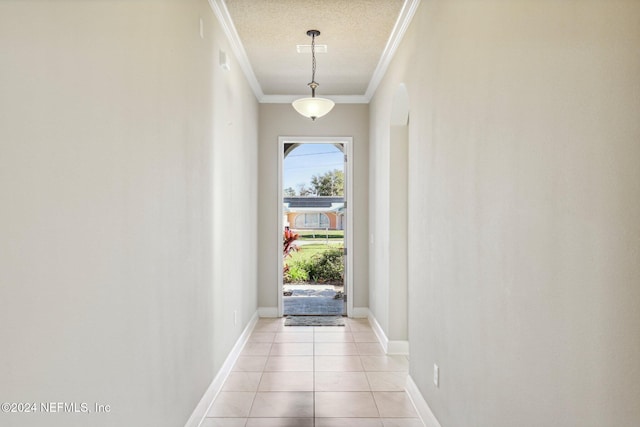 doorway to outside with light tile patterned floors and ornamental molding