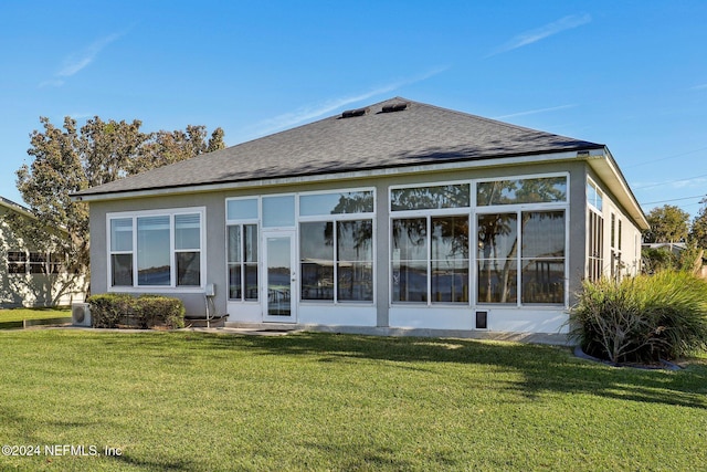 rear view of property featuring a sunroom and a yard