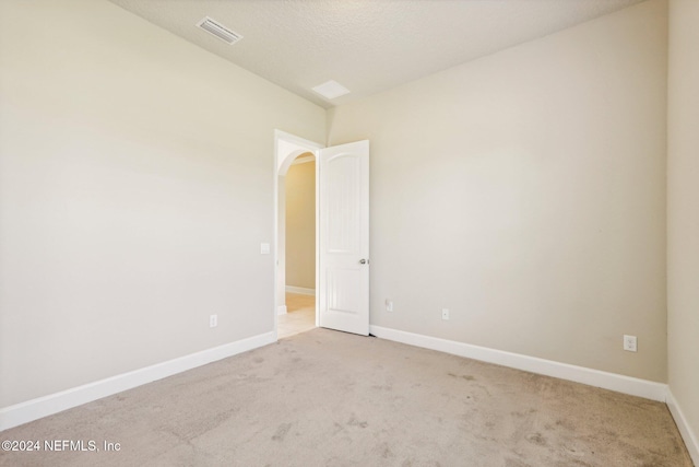 carpeted empty room featuring a textured ceiling