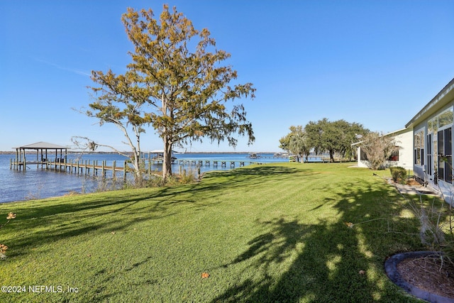 view of yard with a water view and a boat dock